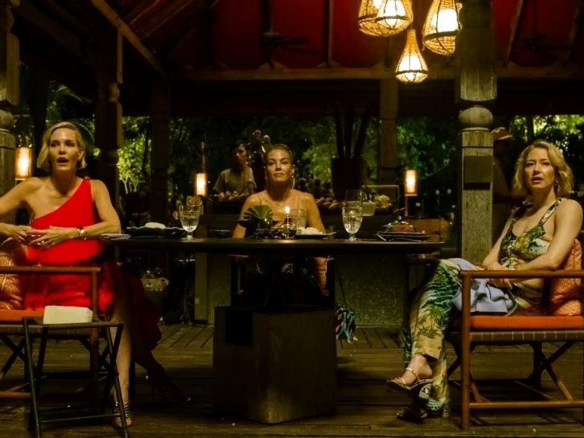 Three woman dining in a luxury hotel in Thailand, turn and look to the camera.