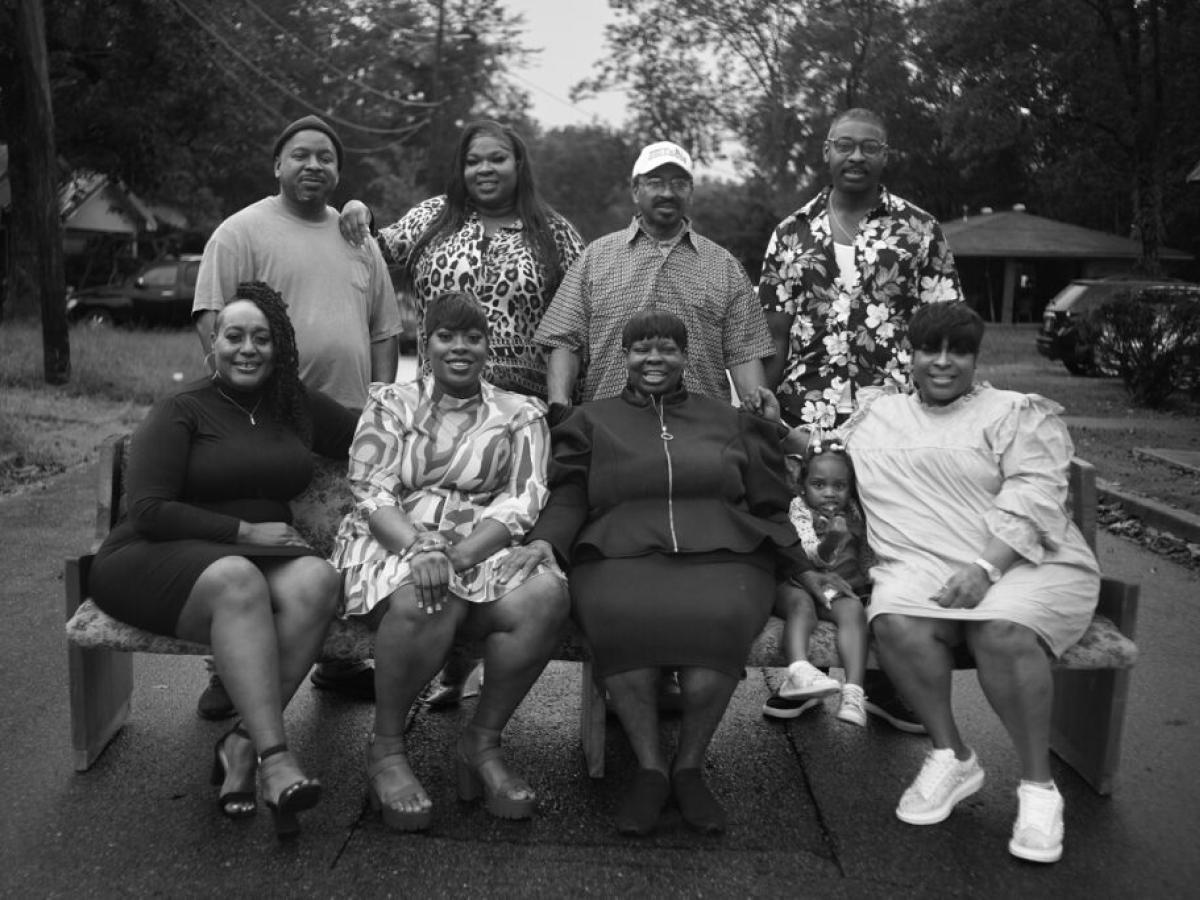 A family group stand and sit for a photo.