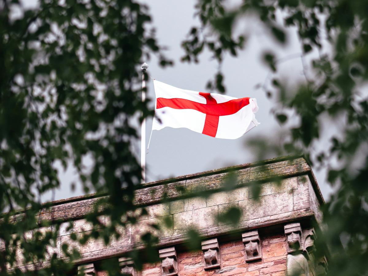 A St George's Cross flag flutters on a tower.