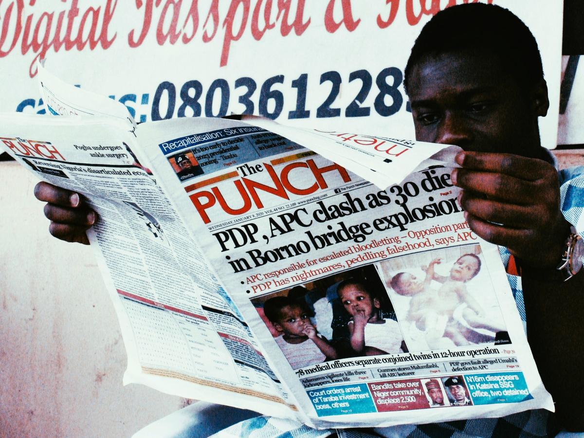 A man reads a newspaper called The Punch.