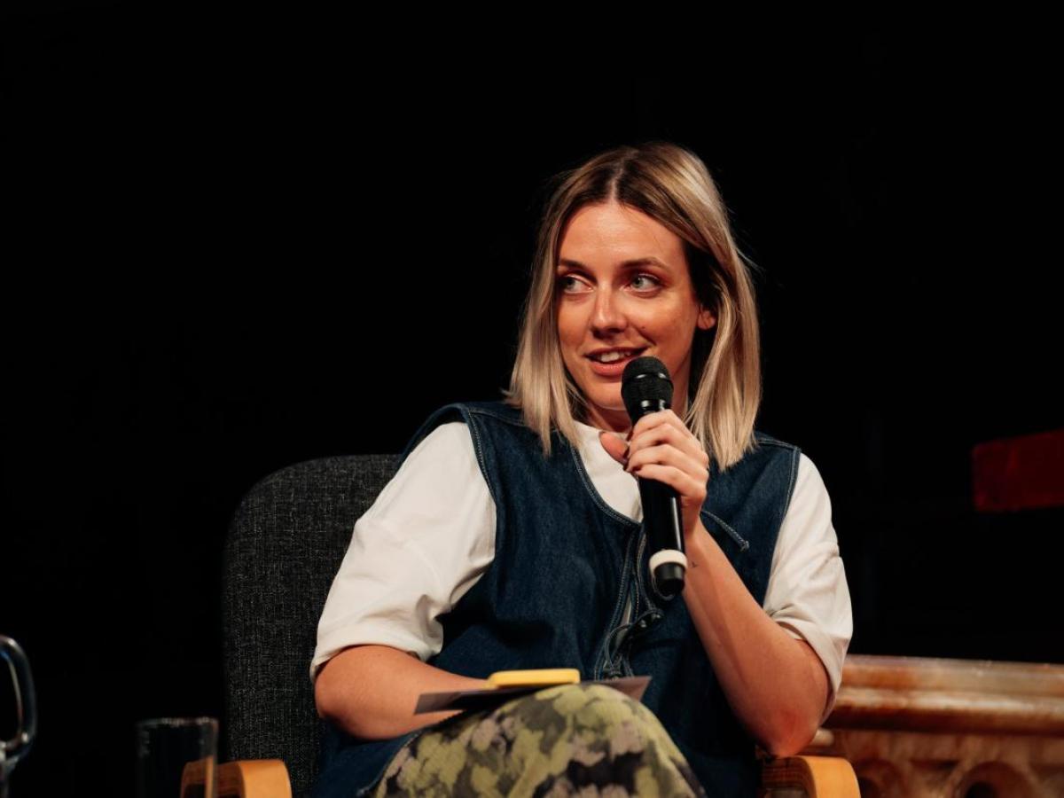 A panelist talks holding a mic.