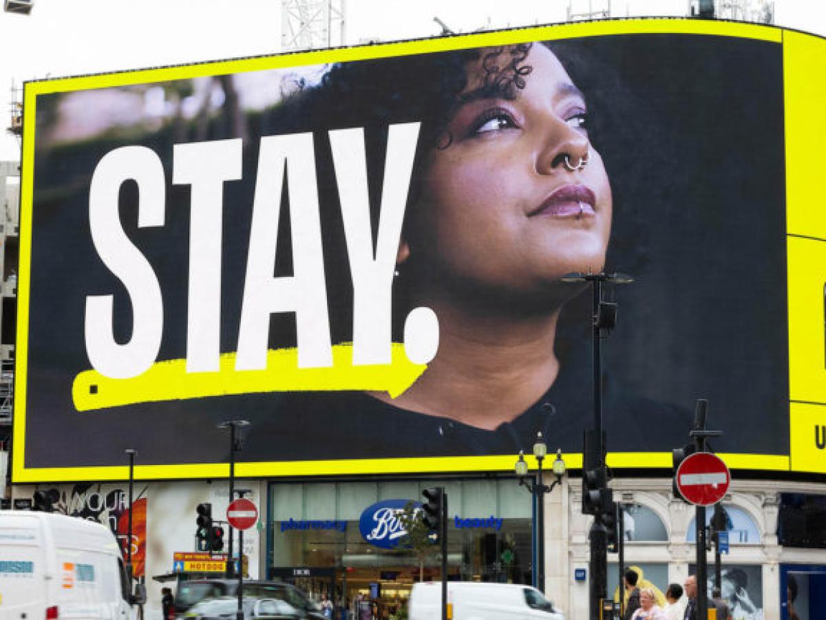 A digital billboard reads: STAY
