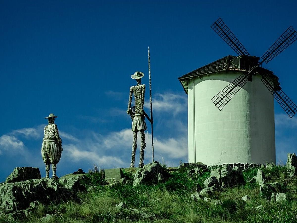 Statues of Don Quixote and Sancho Panza point toward a windmill