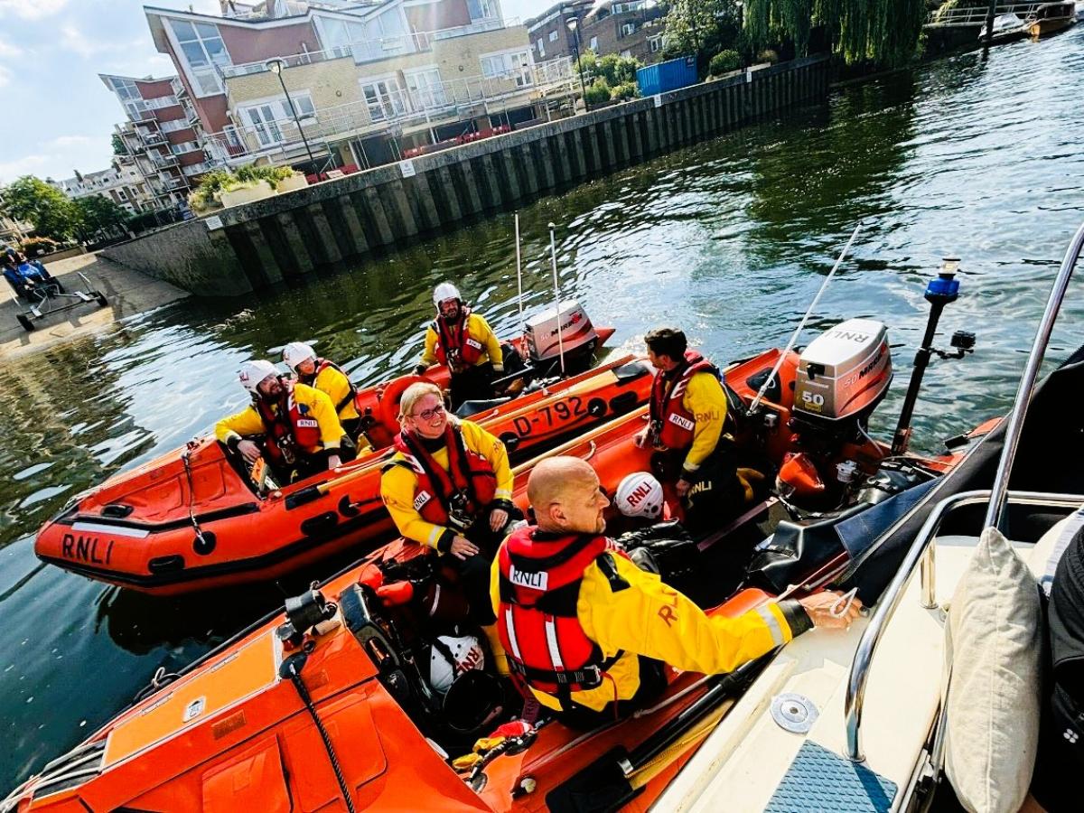 Two small lifeboats raft together on a river rescue.