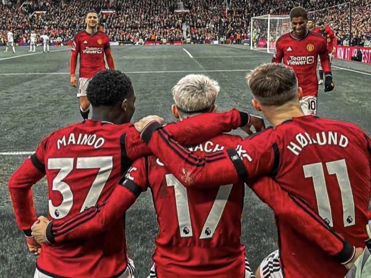 Three Manchester United footballers with their arms around each others backs.