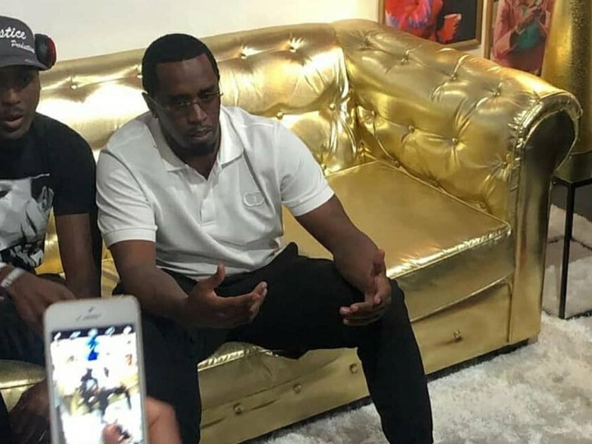 Sean Combs sits on a golden couch.