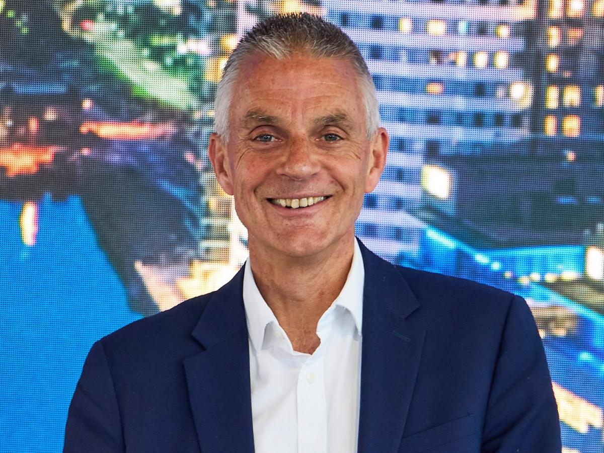 Tim Davie in a blue suite smiles