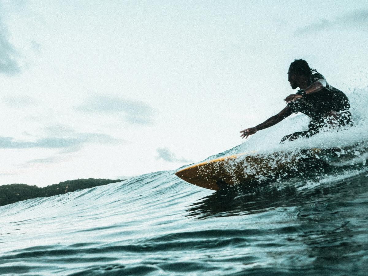 A surfer carves a turn on a wave.