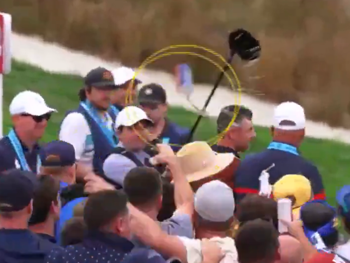 A video still shows a beer can thrown at a golf amid a crows