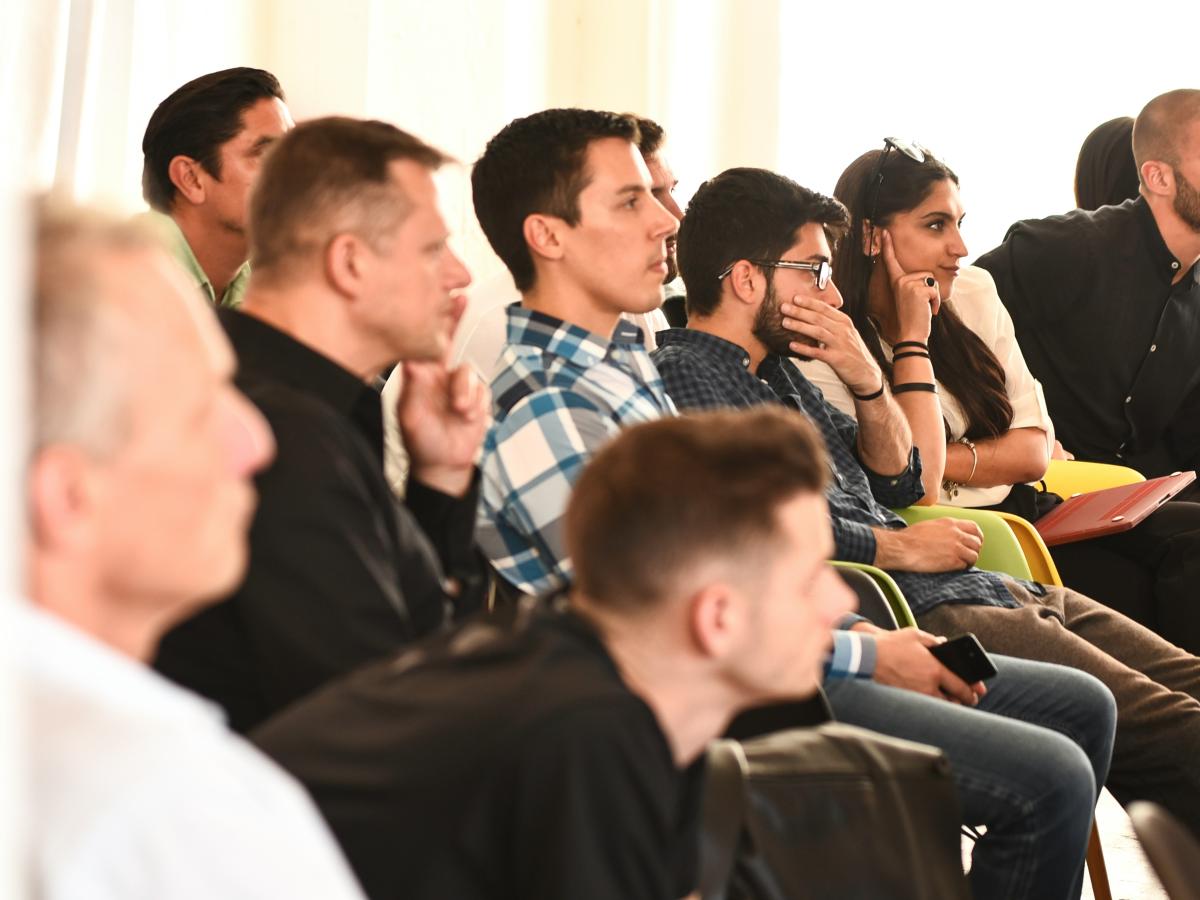 young people listen, and ponder, to a speaker off screen.