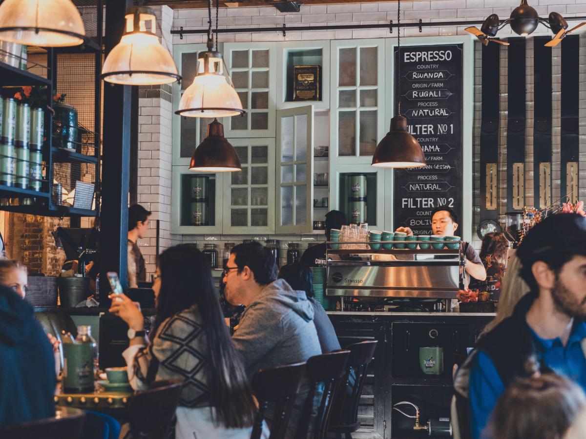 People sit in a busy cafe.