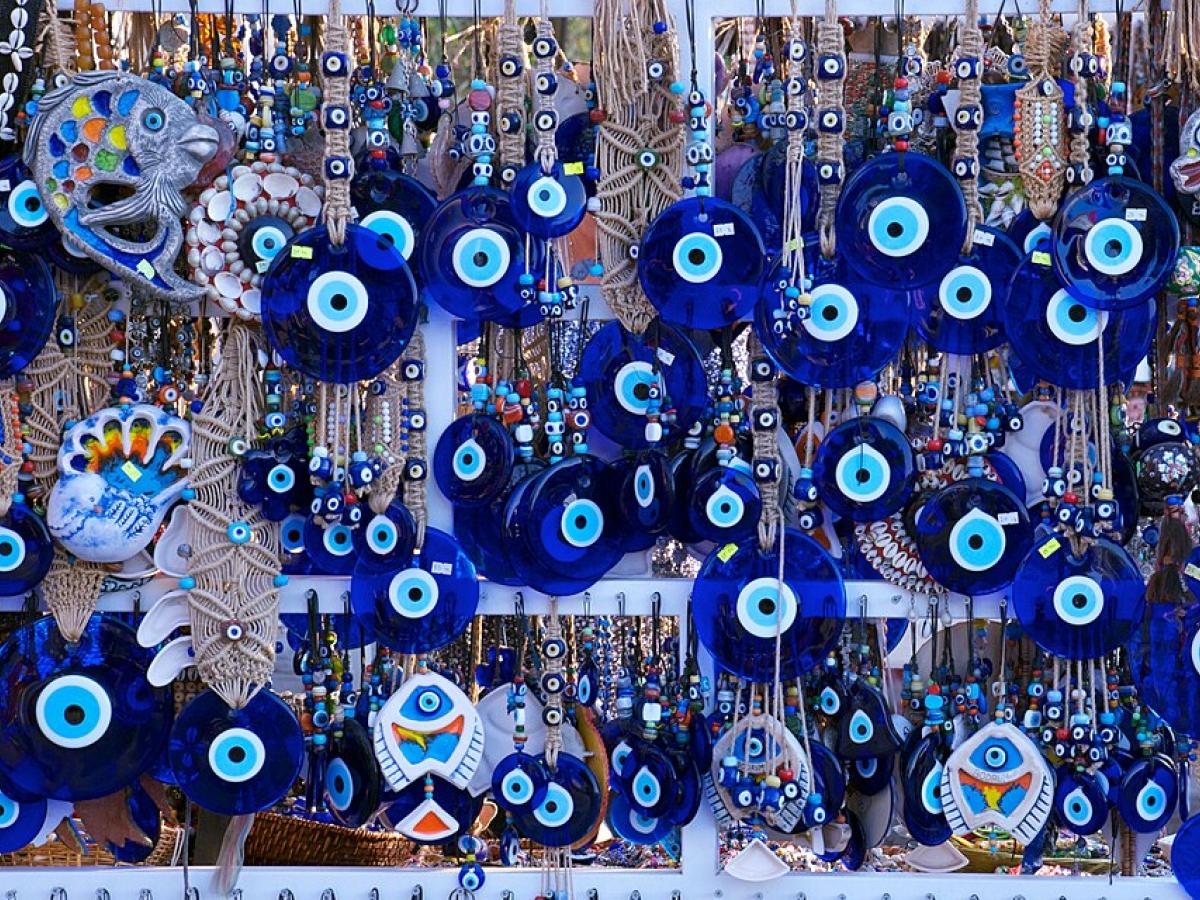 Blue evil eye charms hang among a jewellery display
