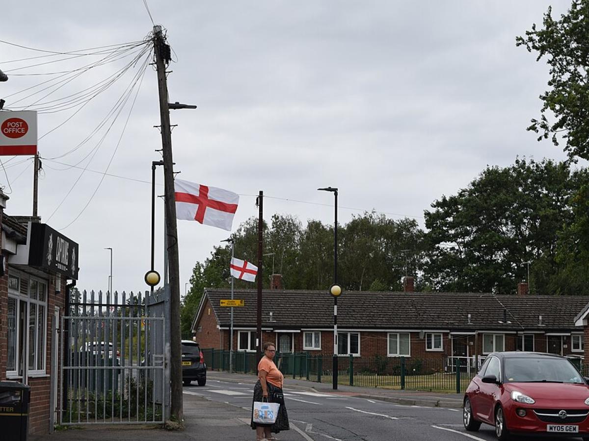 A suburban English street with St George's Cross flags on lamposts. 