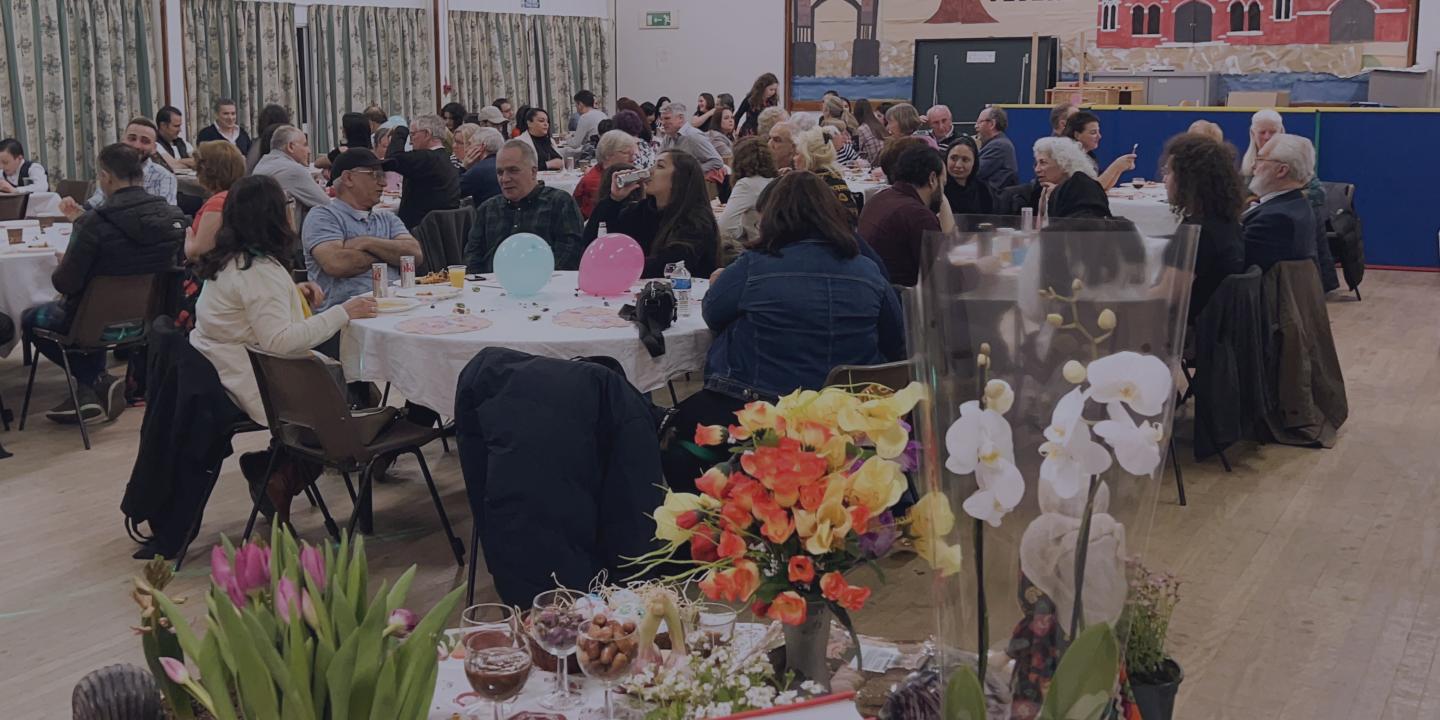 Community members celebrate at lunch in a church hall