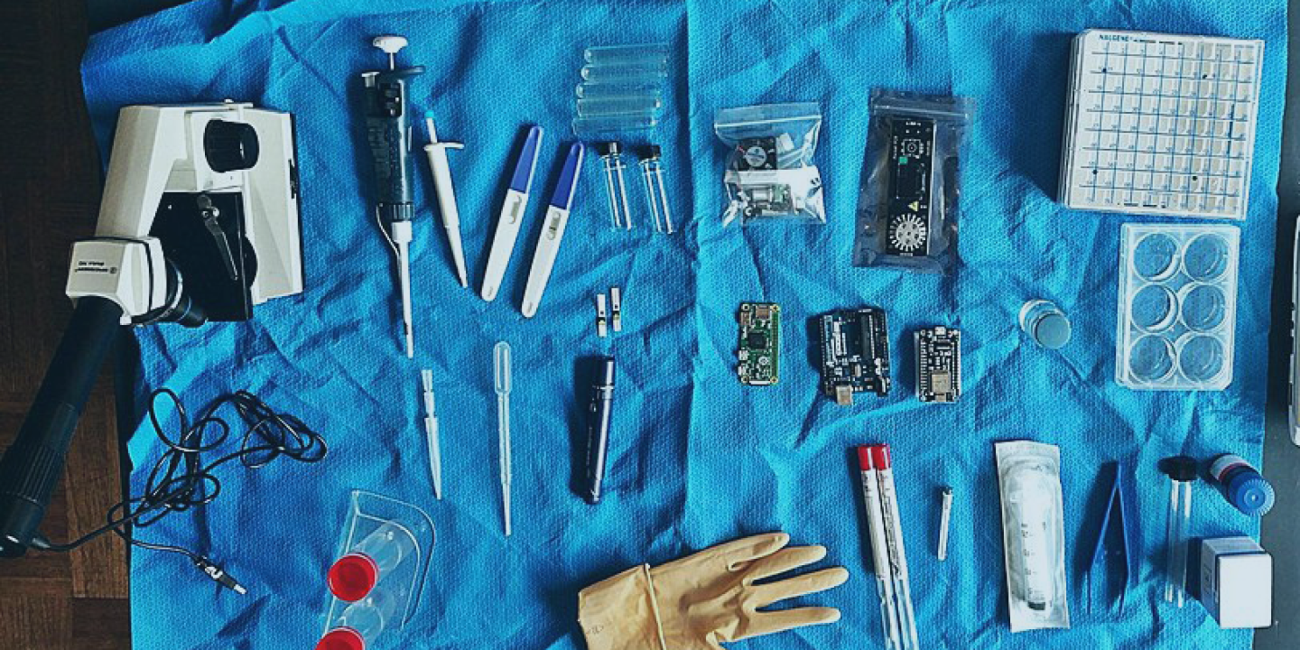 A plastic sheet strewn with biology-related instruments.