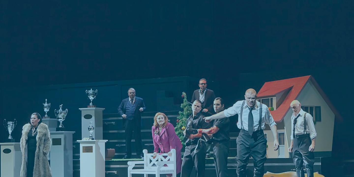 A modern staging of King Lear has the cast across the page. King Lear is front of stage gesturing while the others look on