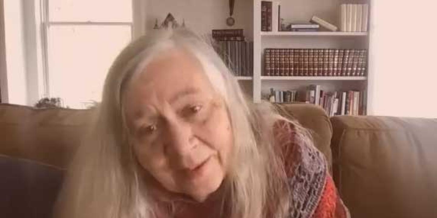 A woman talks while tilting her head to one side.
