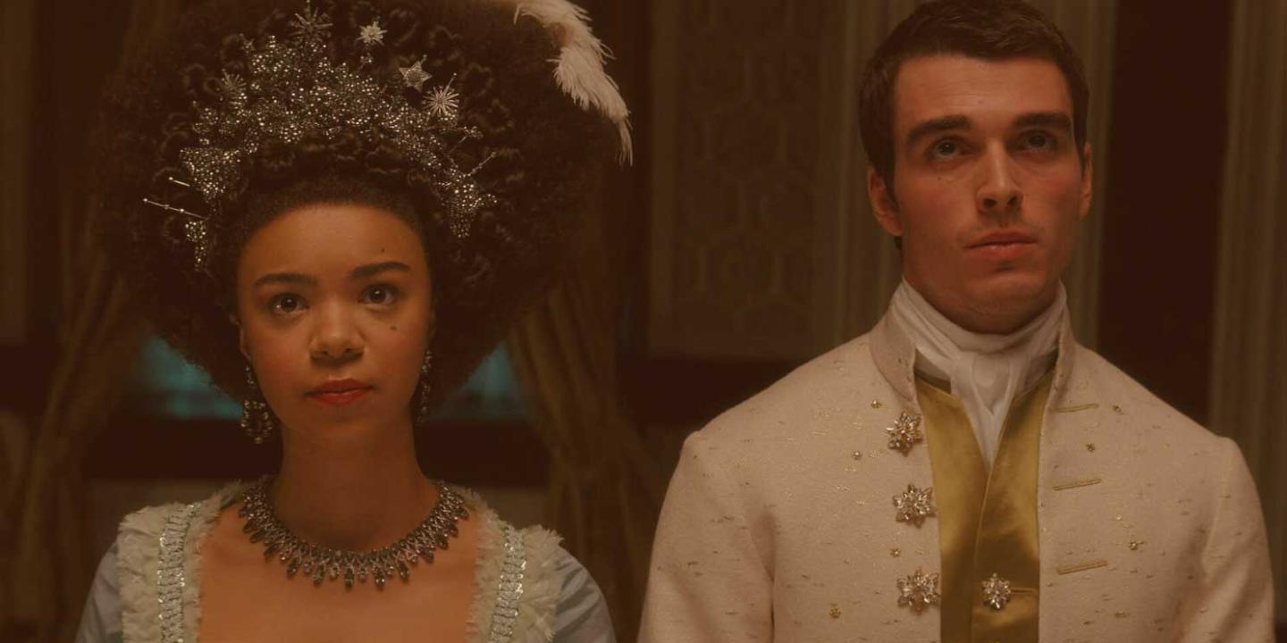 A regency queen and king stand beside each other looking pensive.