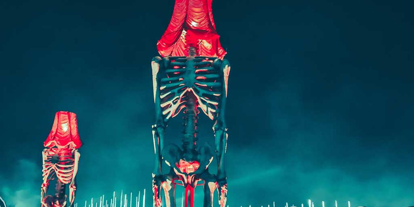 A montage shows skeletons with lamp shades instead if heads beside a fence-like division.