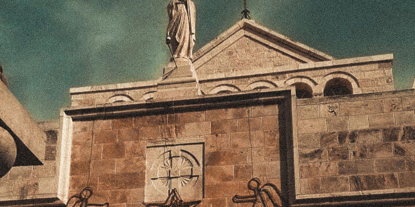 A church gable featuring a cross, a Madonna and angel Christmas decorations.