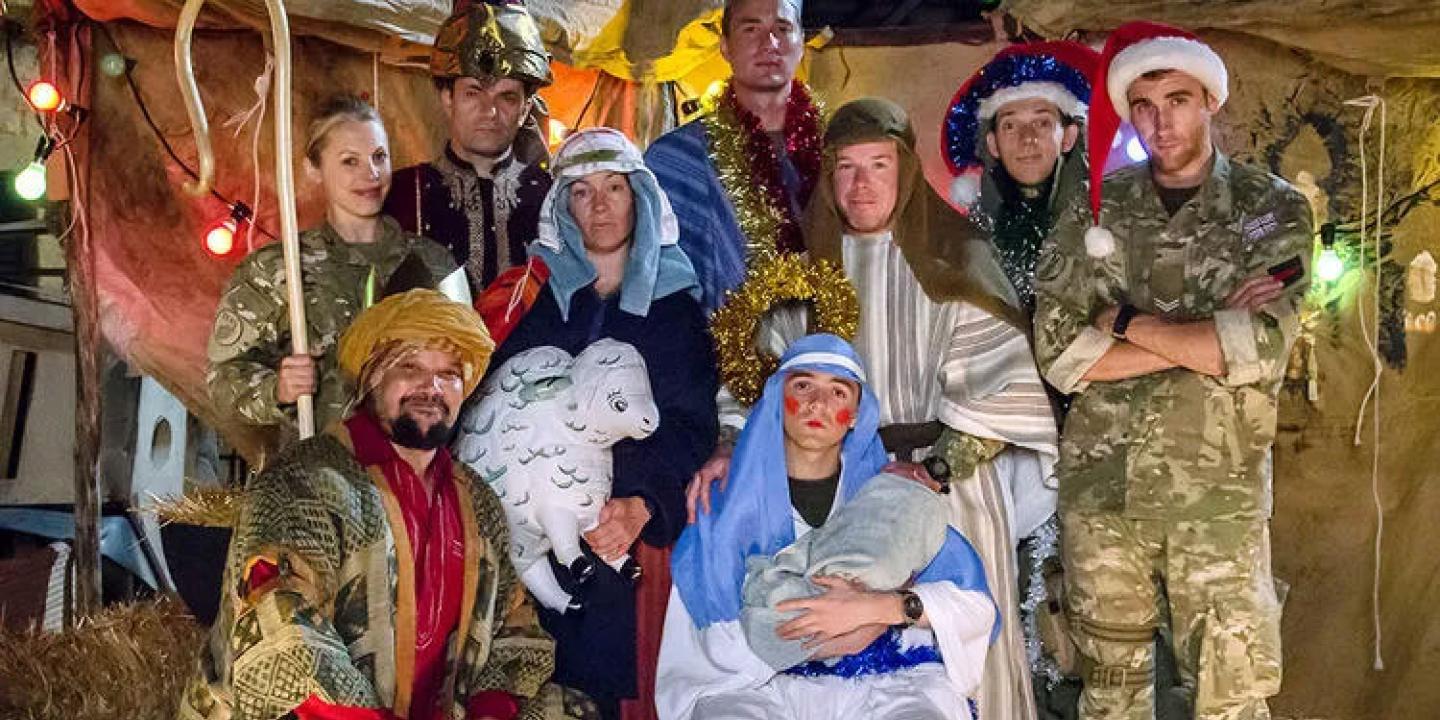 Dressed in camouflage uniforms and makeshift costumes, soldiers create a nativity scene