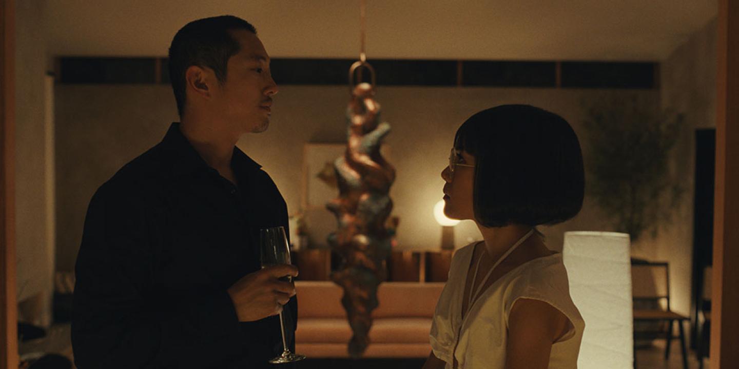 in a dim room a couple stand off against each other. 