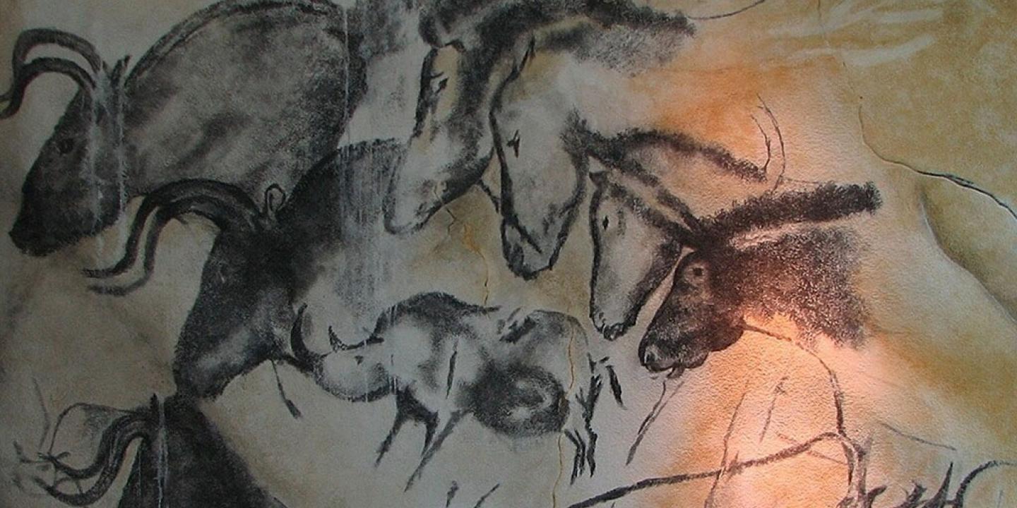 A cave wall drawing of wild animals galloping across other images of themselves.