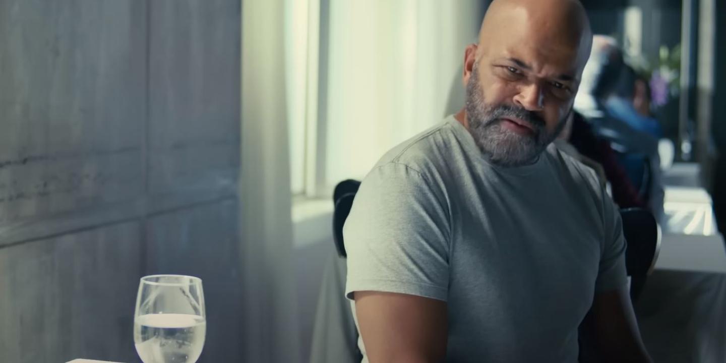 A man sitting at a restaurant table turns and looks aside.