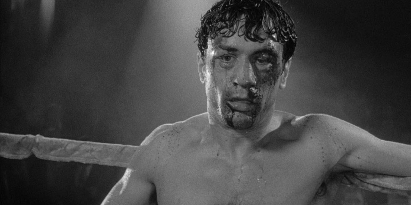 A bloody and shocked boxed leans on the ropes
