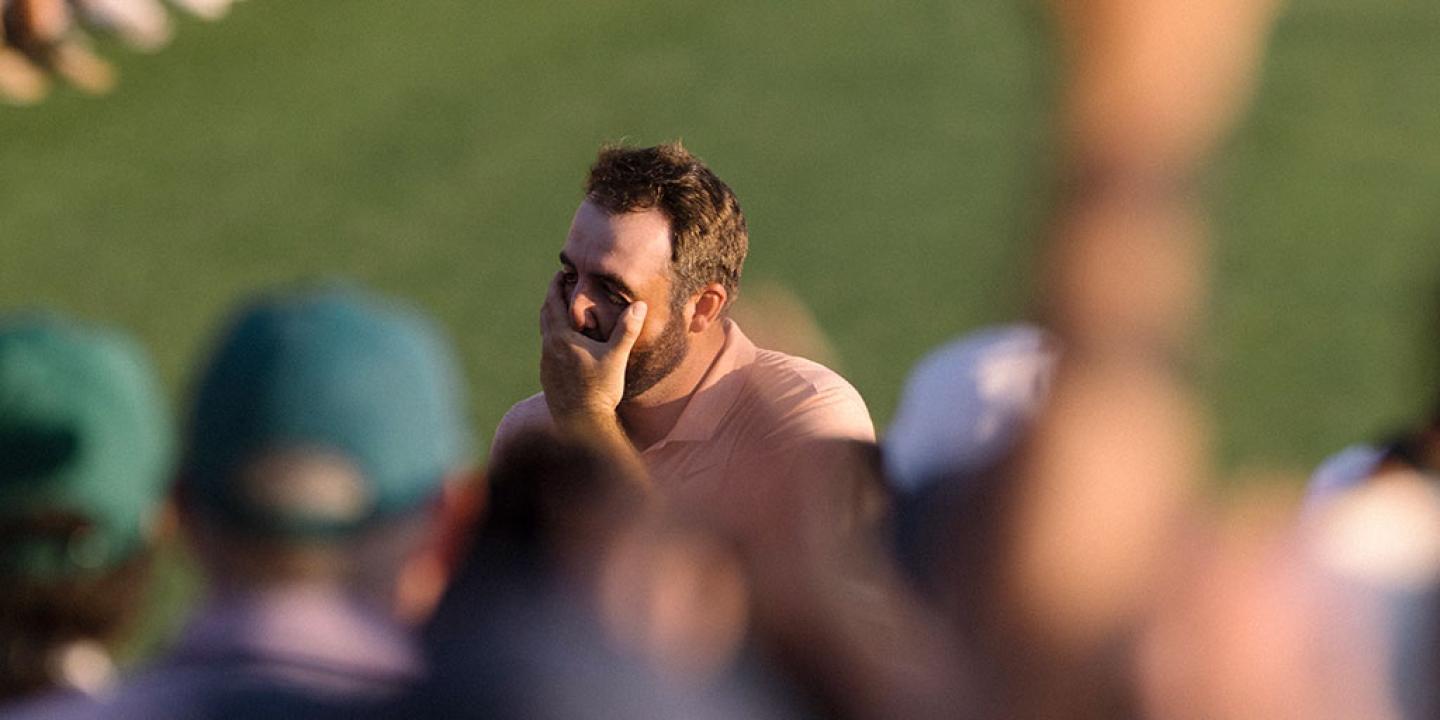 A golfer cups his face as he realises he has won.