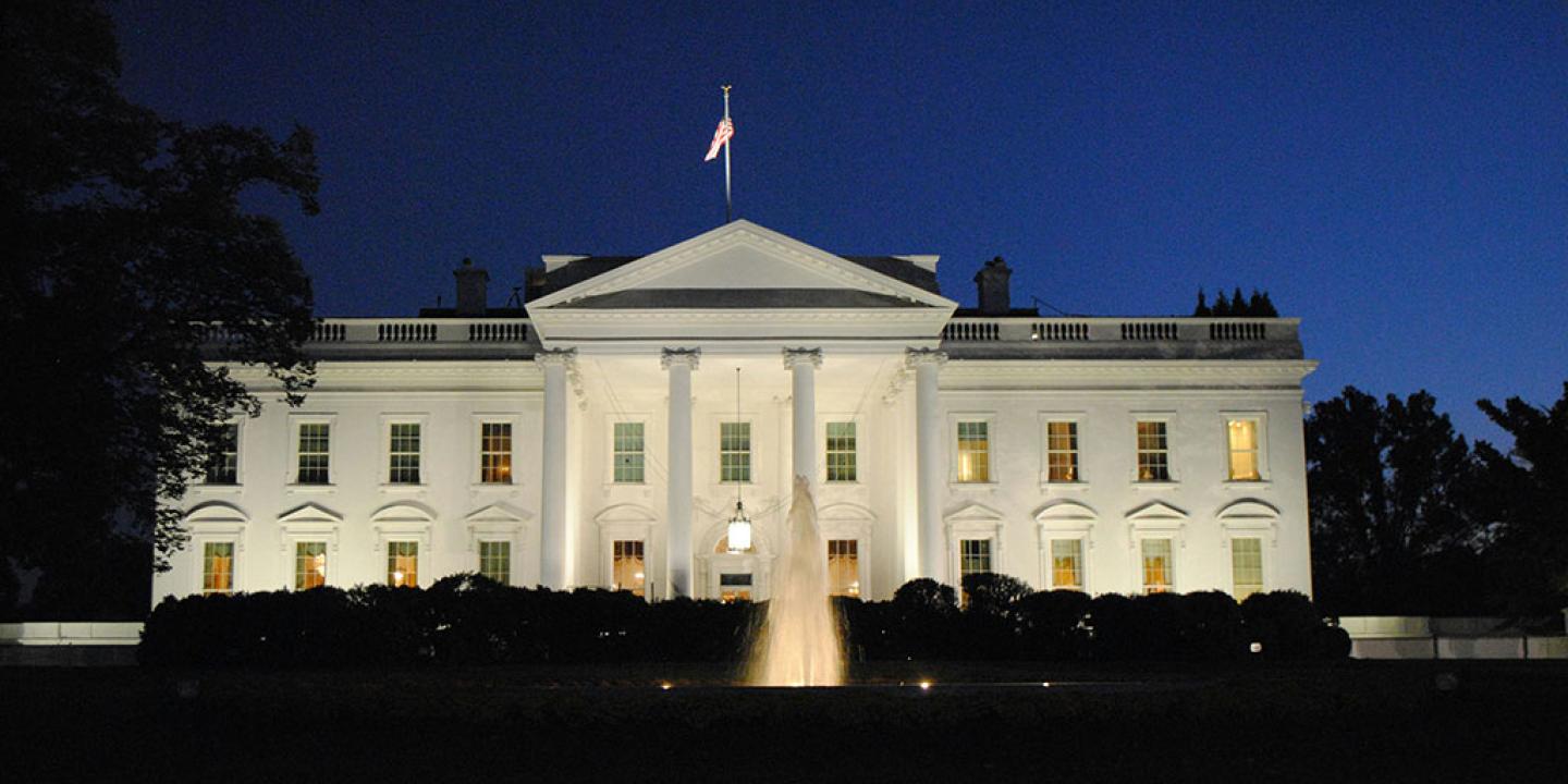 The White House illuminated against the night sky.