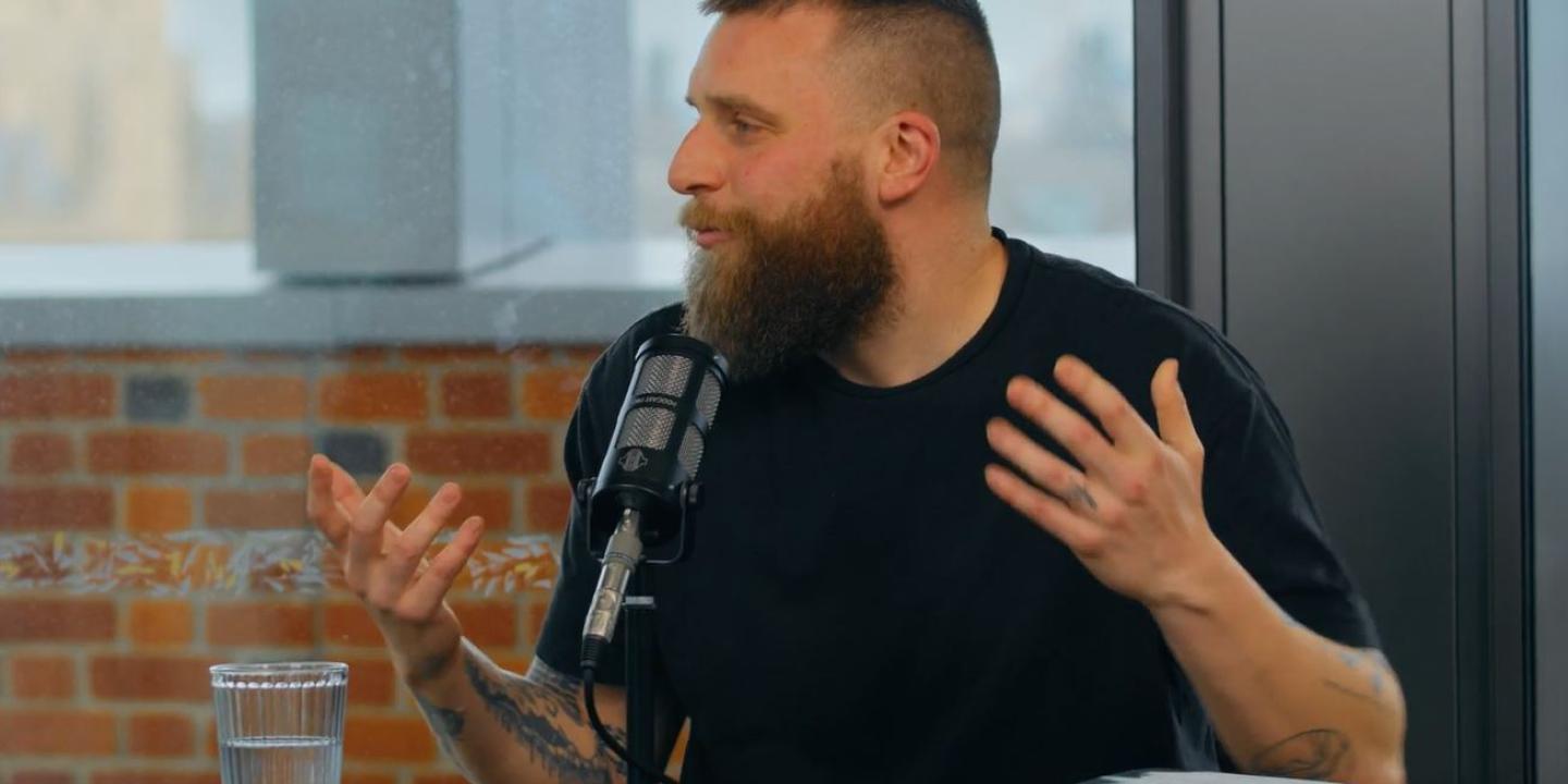 A guest on a podcast, gesture in front of a microphone.