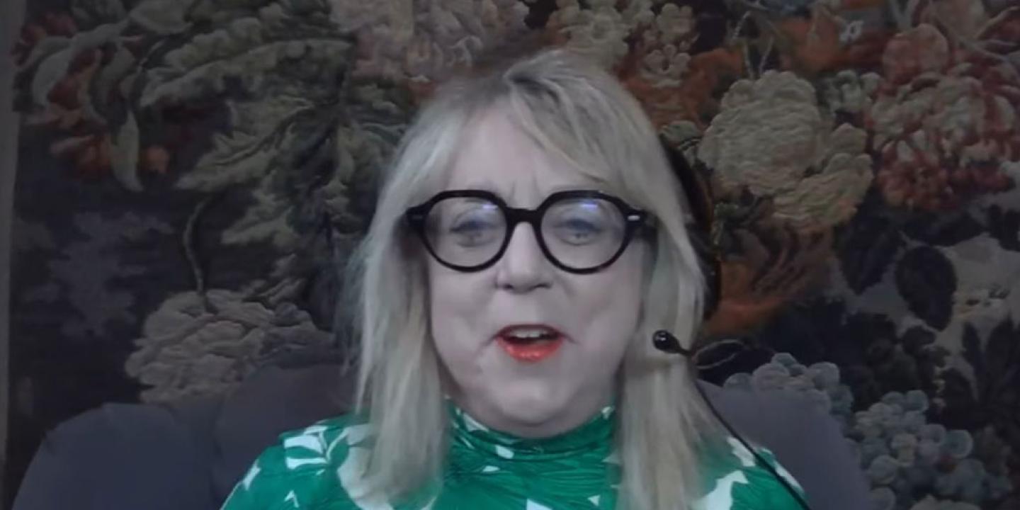 A woman guest on a podcast laughs.