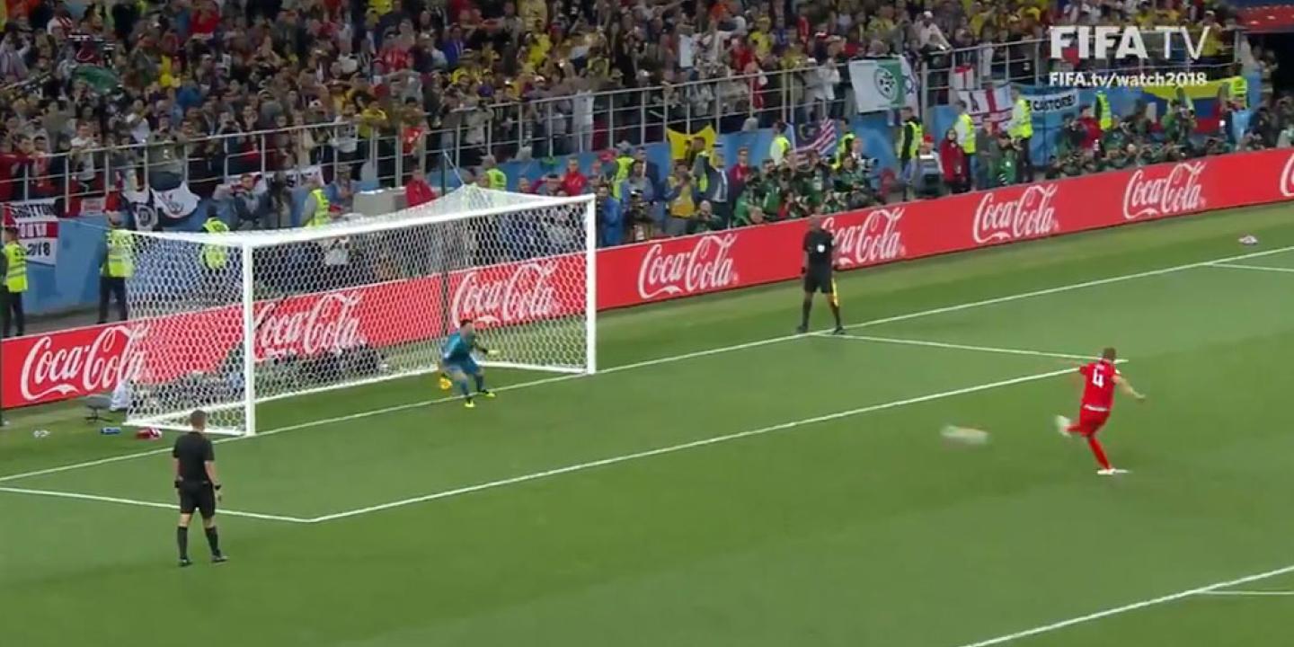 A footballer takes a penalty kick.
