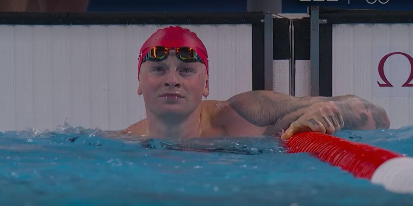 A swimmer at the end of a race, looks to the result screen.
