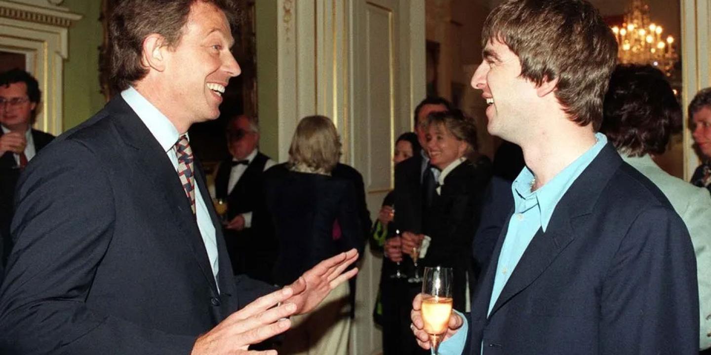 Tony Blair talks to a member of Oasis at a reception.