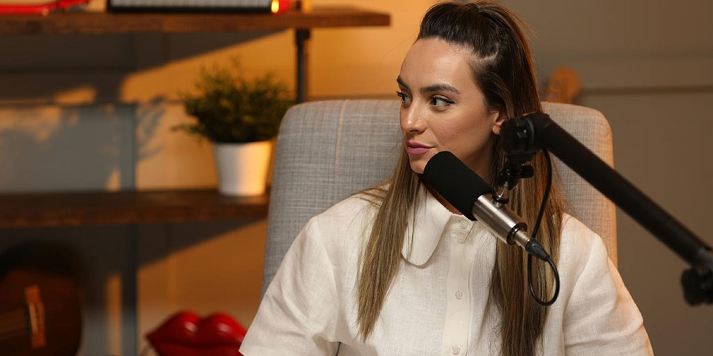 A podcast guest speaks in front of a mic.