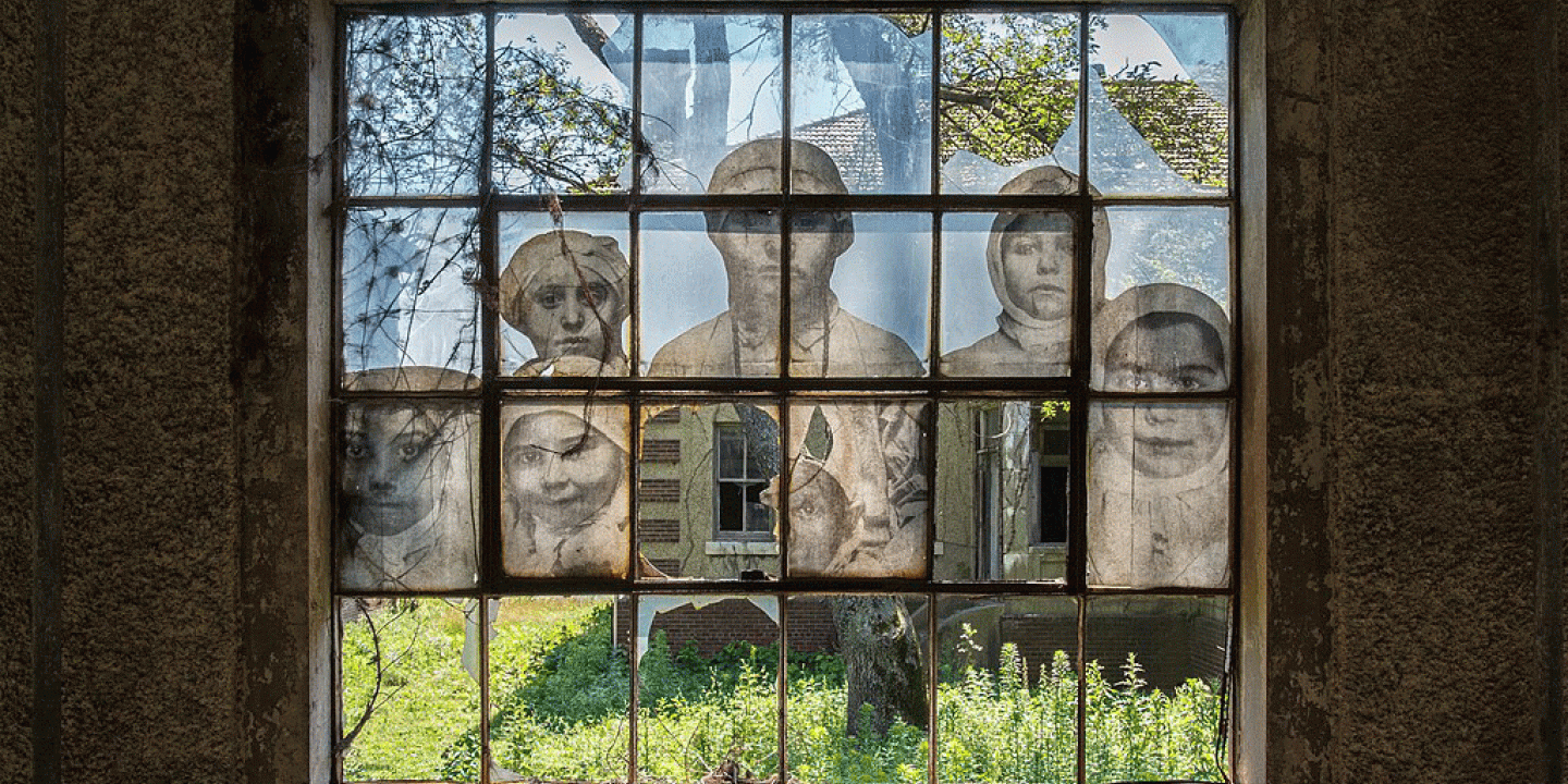 a multi-paned window mural shows people while amid it are broken window panes.