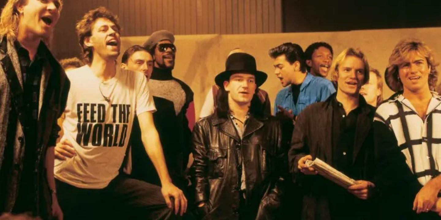 Pop stars sing together while recording a charity single.