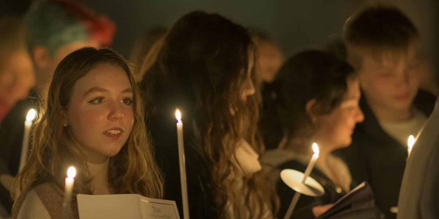 Carol singers, lit by candle light.