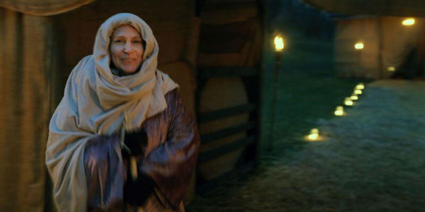 A woman dressed as a historical Middle Eastern innkeeper's wife.