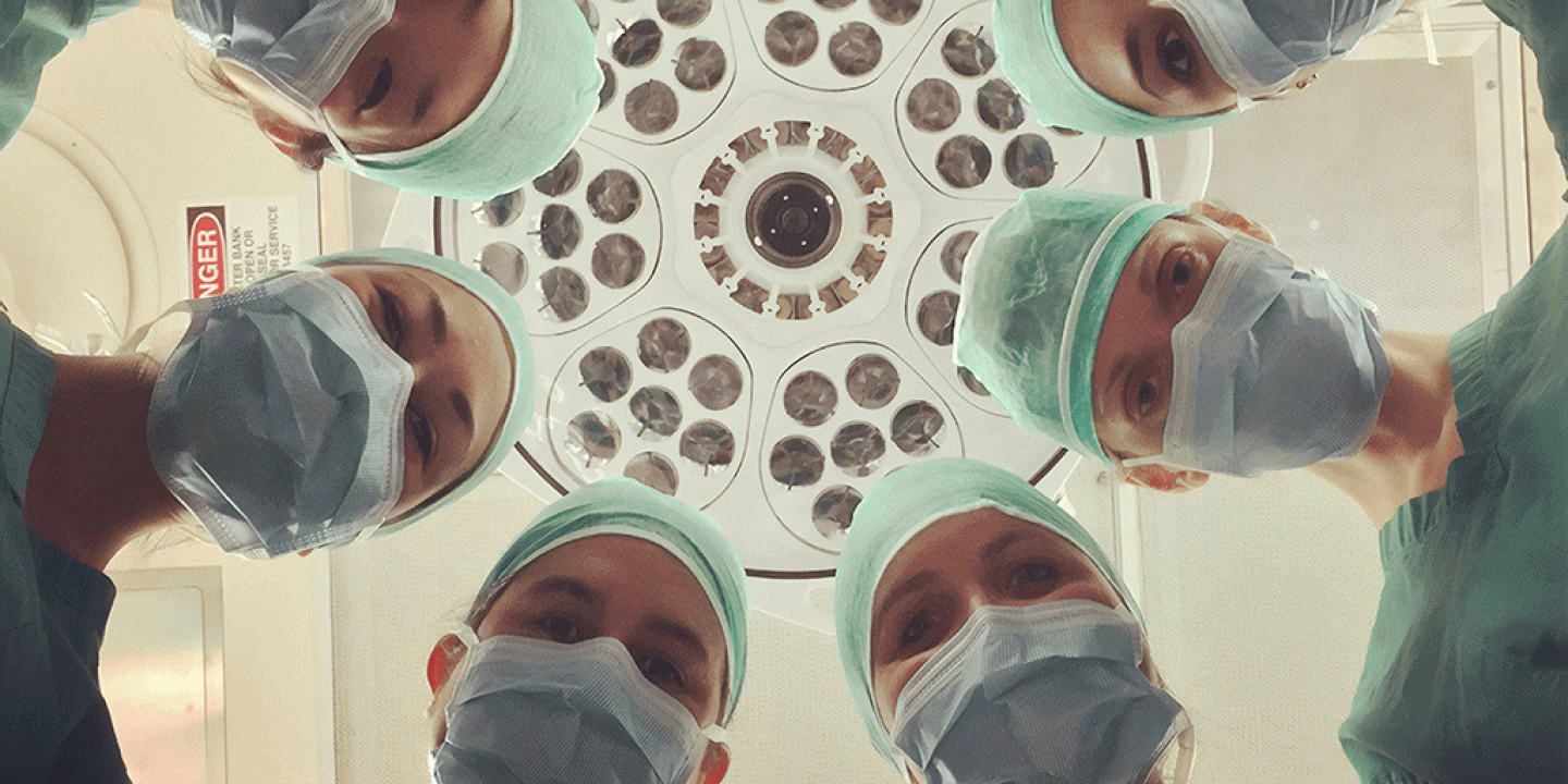 A patient eye view of six surgeons looking down.