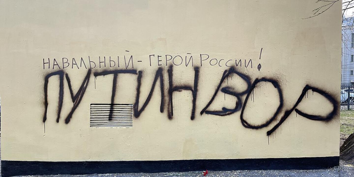 Graffiti on a wall, spells out in Russian character the name Navalny.