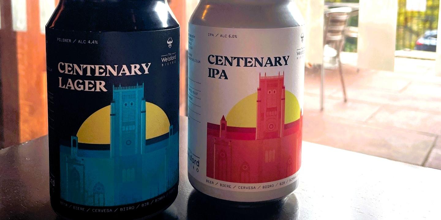 Two cans of beer depict a drawing of a cathedral.