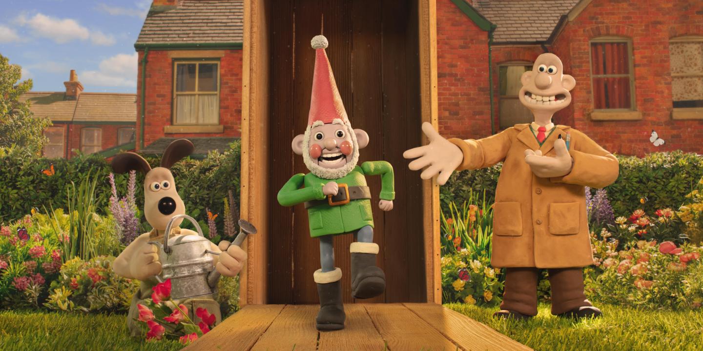 A still from a claymantion film shows three characters, Wallace, Gromit and a robot garden gnome marching out a garden shed.