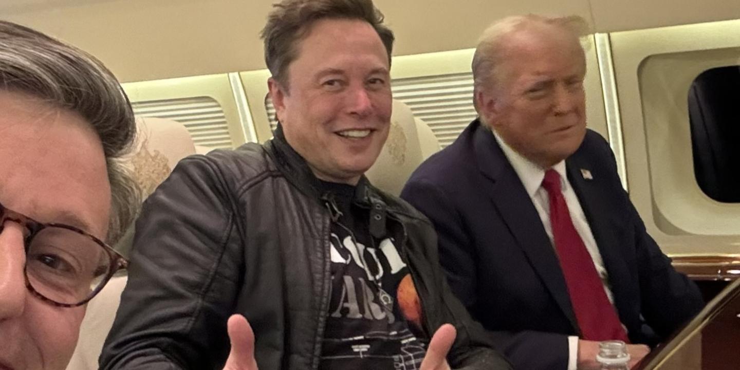 Elon Musk sits next to Donald Trump on a plan, while giving the thumbs up gesture with both hands.