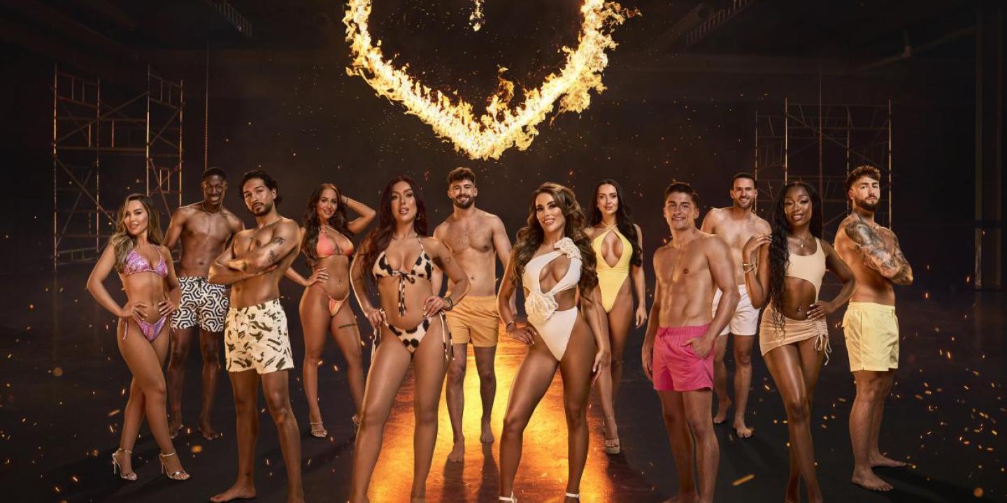 A Composite image of Love Island contestants stand together in a group under a fiery heart.