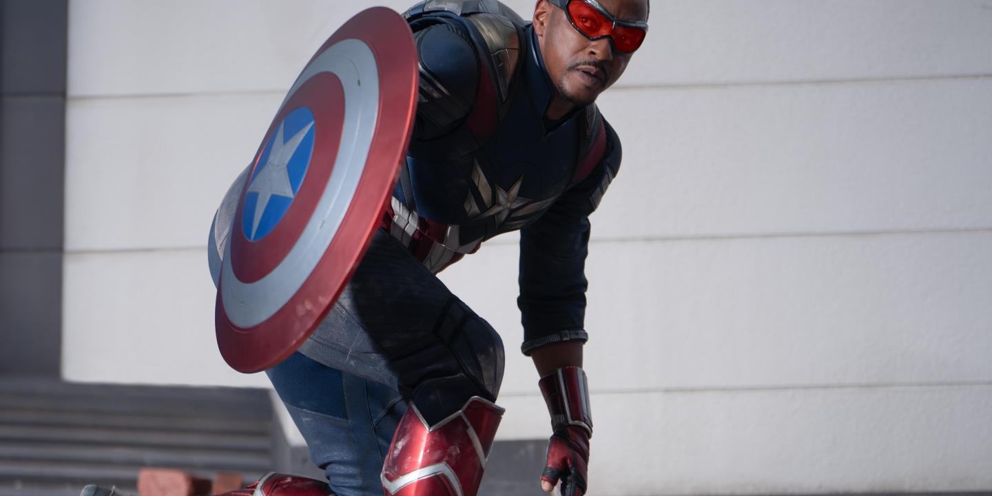 Captain America crouches expectantly beside his shield