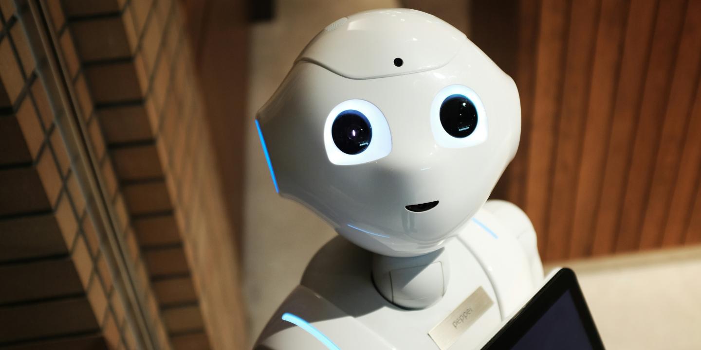 A cute-looking robot with big eyes stares up at the viewer.
