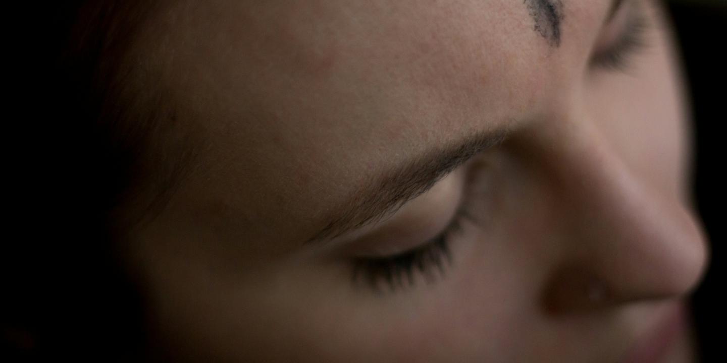 A close up of a forehead bearing an ash cross marked on it.